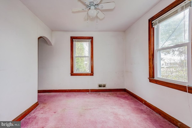 carpeted empty room featuring ceiling fan and plenty of natural light