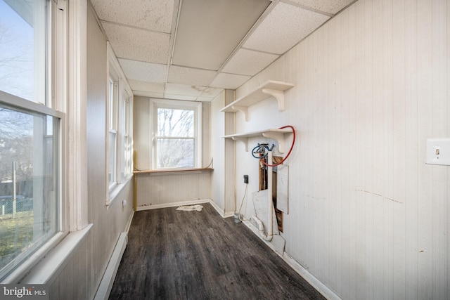 laundry area with dark hardwood / wood-style flooring, a baseboard radiator, and wood walls