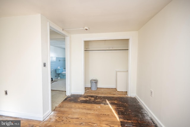 unfurnished bedroom featuring a closet and dark hardwood / wood-style floors