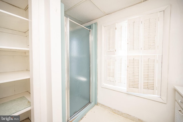 bathroom with vanity, an enclosed shower, and a paneled ceiling