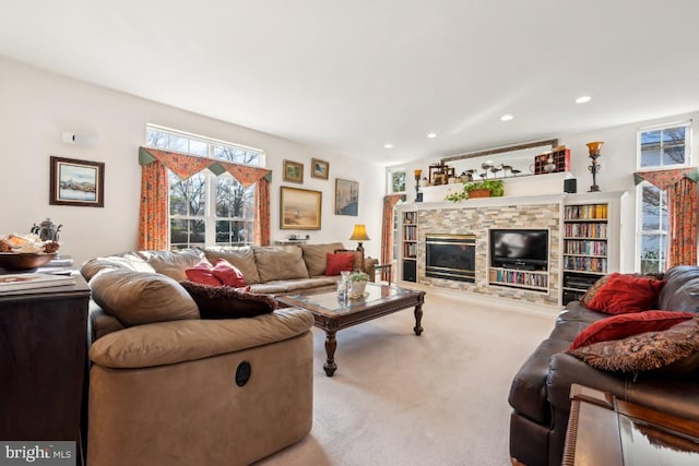 living room with carpet and a stone fireplace