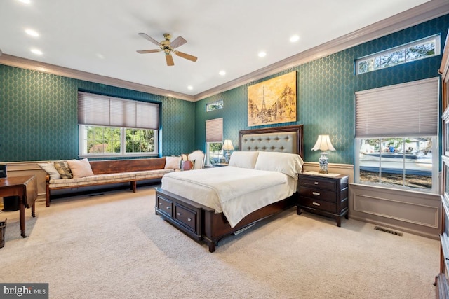 carpeted bedroom with ceiling fan and ornamental molding