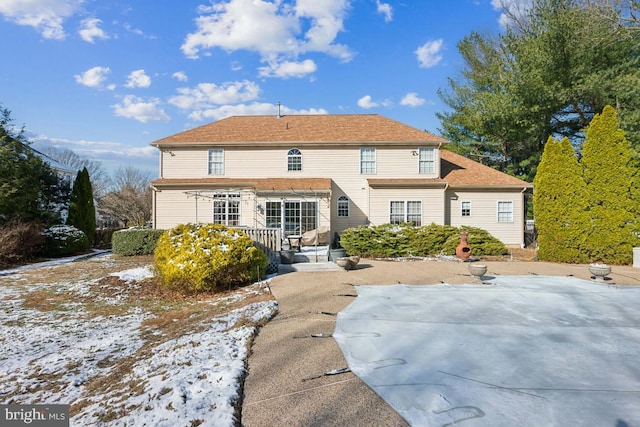 view of snow covered rear of property