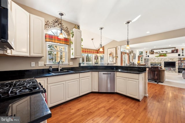 kitchen with decorative light fixtures, white cabinetry, and sink