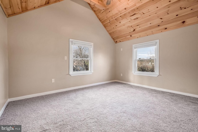 carpeted empty room with wood ceiling and high vaulted ceiling