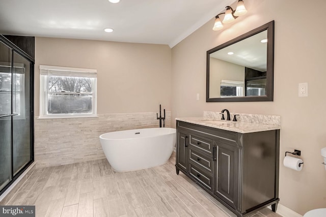 bathroom featuring vanity, separate shower and tub, ornamental molding, tile walls, and wood-type flooring