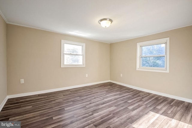 empty room featuring crown molding, plenty of natural light, and hardwood / wood-style floors