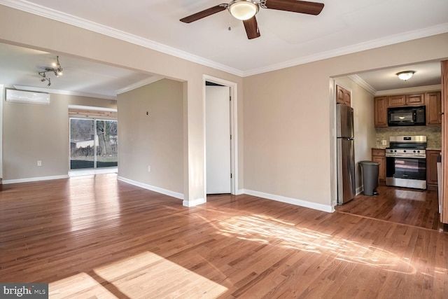 unfurnished living room with ceiling fan, ornamental molding, a wall unit AC, and light hardwood / wood-style flooring