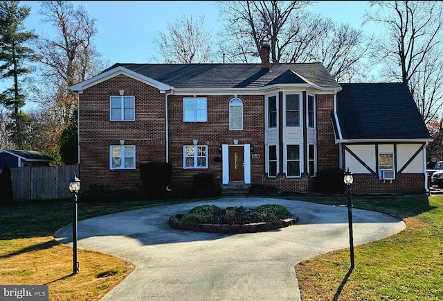 view of front of house with a front lawn and cooling unit