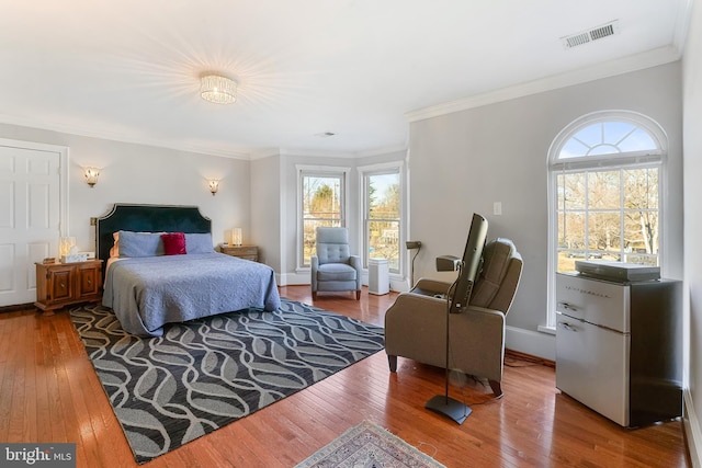 bedroom with hardwood / wood-style flooring and ornamental molding