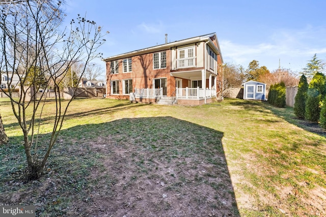 rear view of house featuring a storage shed and a yard