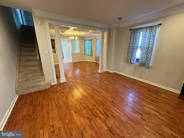 empty room with hardwood / wood-style flooring, a notable chandelier, and ornamental molding