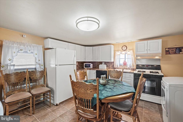 kitchen with white cabinets, washer / dryer, and white appliances