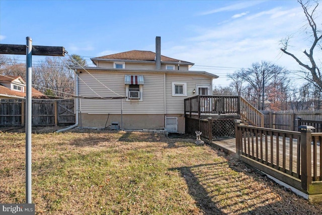 rear view of house featuring a wooden deck and a yard