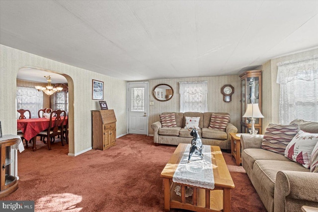 carpeted living room featuring a healthy amount of sunlight and a chandelier