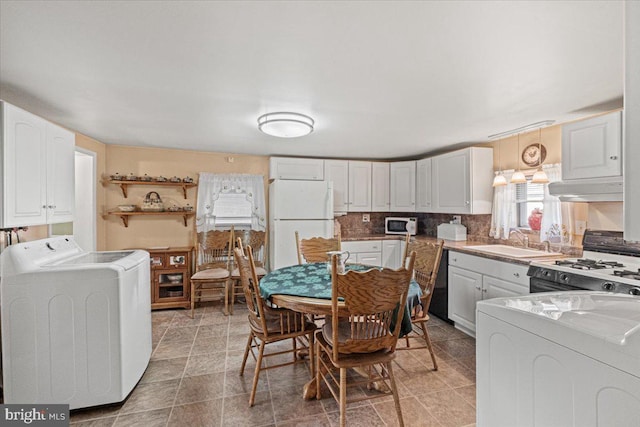 kitchen featuring white cabinetry, sink, tile patterned flooring, independent washer and dryer, and black appliances