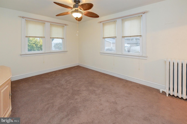 carpeted empty room featuring radiator and ceiling fan