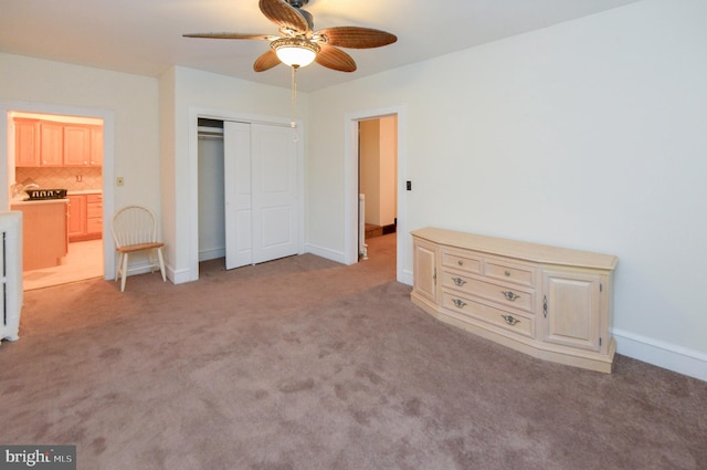 unfurnished bedroom featuring ceiling fan, light carpet, connected bathroom, and a closet