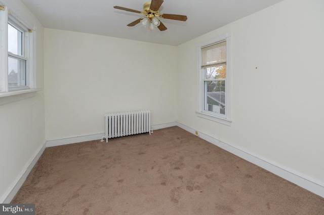 empty room with light carpet, radiator heating unit, and ceiling fan