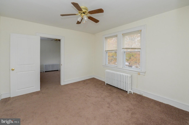 carpeted spare room with ceiling fan and radiator