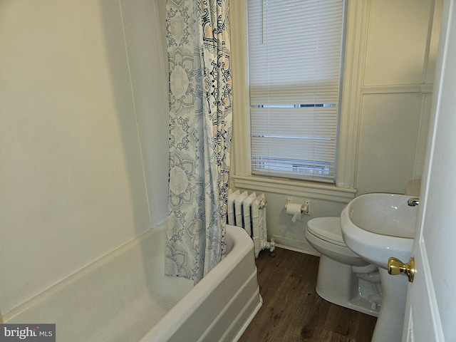 full bathroom with hardwood / wood-style floors, sink, toilet, shower / tub combo with curtain, and radiator heating unit