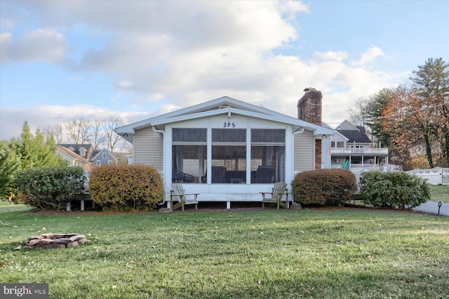 back of property featuring a yard and a sunroom