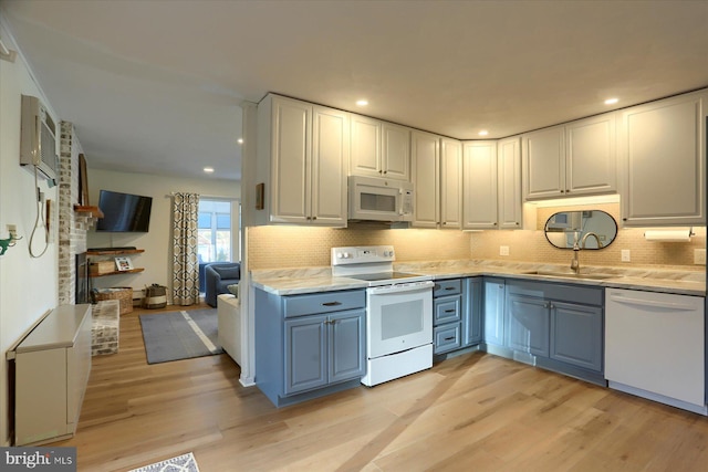 kitchen featuring white cabinetry, white appliances, sink, and light hardwood / wood-style flooring