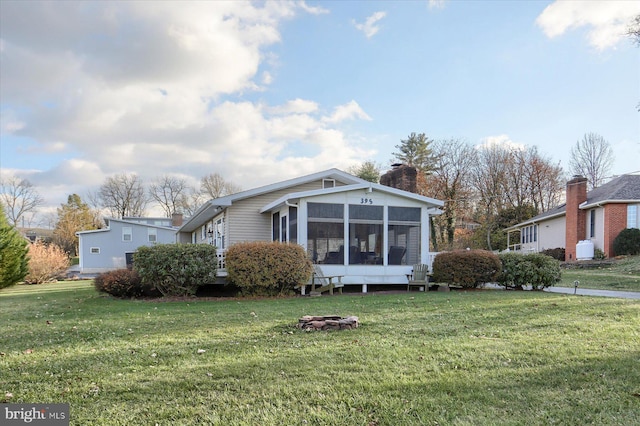 view of front facade with a sunroom and a front yard