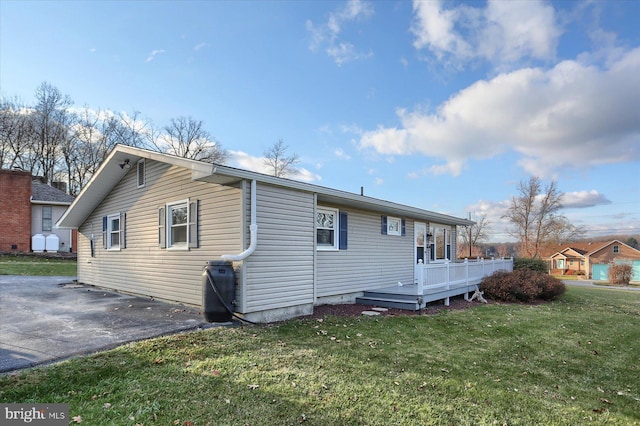 back of property with a yard and a deck