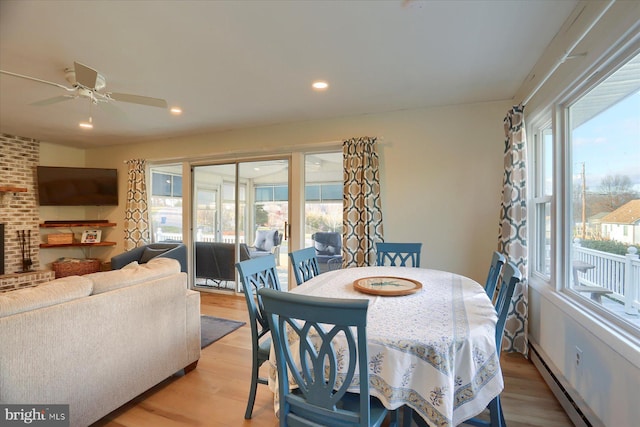 dining area featuring light hardwood / wood-style flooring, baseboard heating, plenty of natural light, and ceiling fan