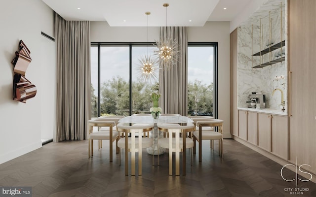 dining space featuring a notable chandelier, dark parquet flooring, and sink