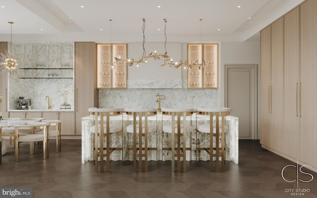 kitchen featuring dark parquet flooring, light brown cabinets, pendant lighting, and a notable chandelier