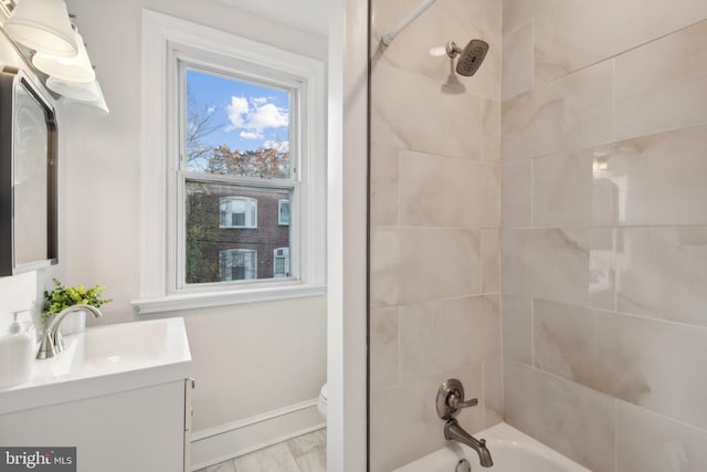 full bathroom featuring vanity, tiled shower / bath combo, and toilet