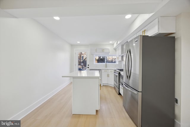 kitchen with a center island, white cabinets, light hardwood / wood-style flooring, appliances with stainless steel finishes, and tasteful backsplash