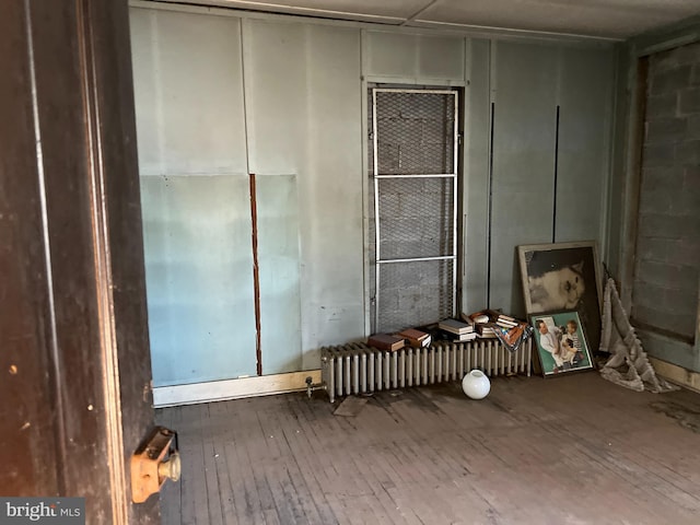 miscellaneous room with hardwood / wood-style floors and radiator