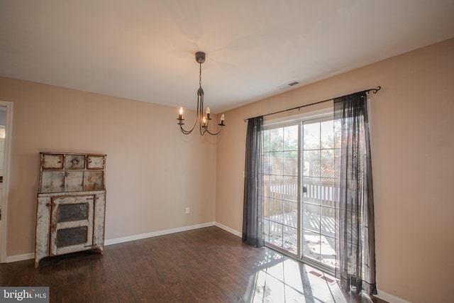 unfurnished living room featuring dark wood-type flooring and a notable chandelier