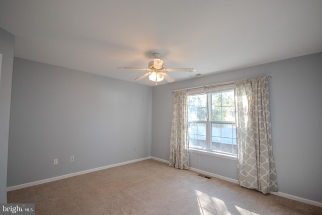 carpeted spare room featuring ceiling fan