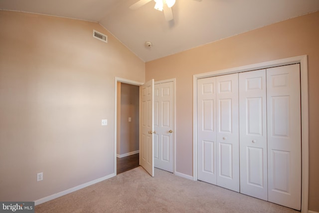 unfurnished bedroom with ceiling fan, lofted ceiling, light carpet, and a closet