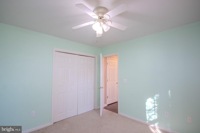 unfurnished bedroom with ceiling fan, a closet, and light colored carpet