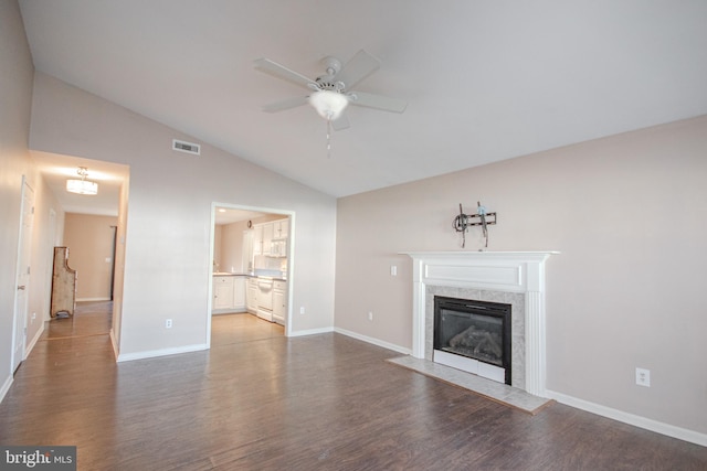 unfurnished living room featuring ceiling fan, wood-type flooring, a tile fireplace, and vaulted ceiling