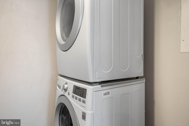 clothes washing area with stacked washer / dryer