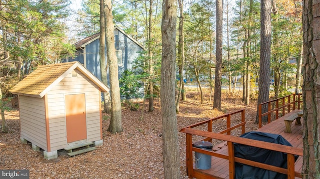 view of yard featuring a storage shed and a wooden deck