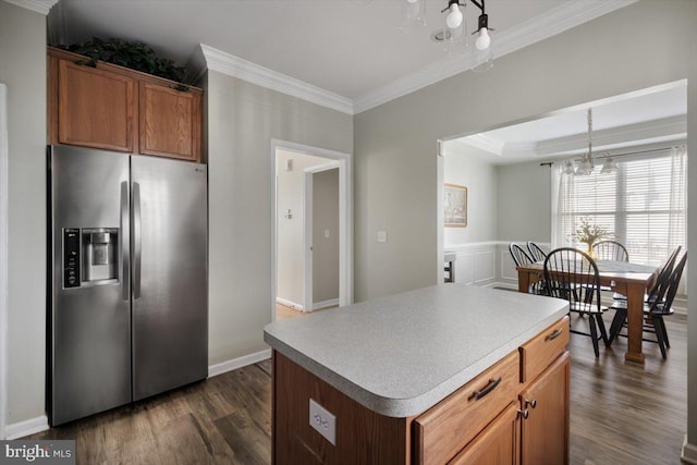 kitchen featuring stainless steel fridge with ice dispenser, dark hardwood / wood-style flooring, a kitchen island, and ornamental molding