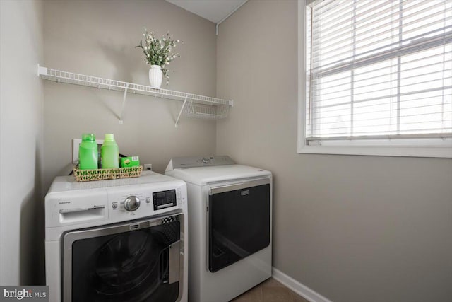 washroom featuring tile patterned floors, a healthy amount of sunlight, and independent washer and dryer