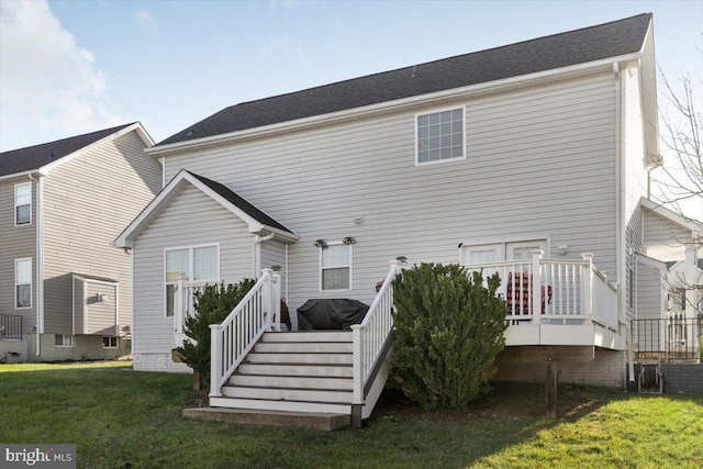 back of house featuring a lawn and a deck