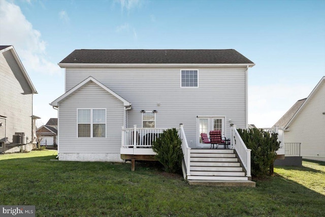 rear view of house featuring a deck and a lawn