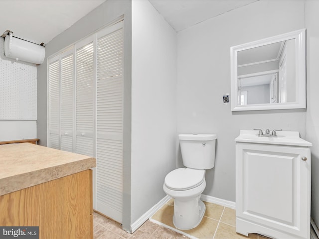 bathroom with tile patterned flooring, vanity, and toilet