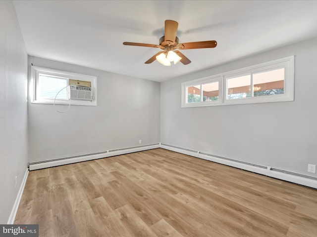 empty room featuring light hardwood / wood-style floors, a baseboard radiator, a wealth of natural light, and ceiling fan