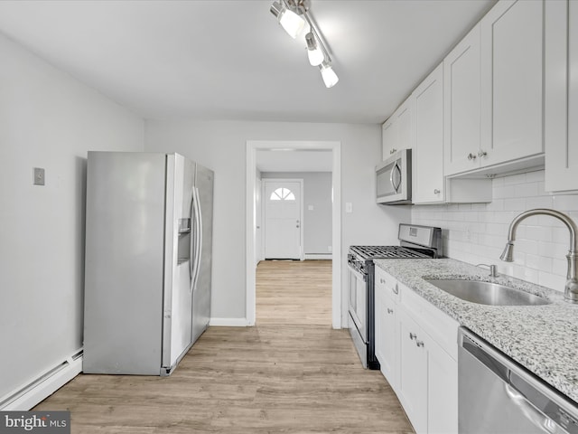 kitchen featuring white cabinets, baseboard heating, sink, and appliances with stainless steel finishes