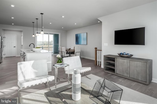 living room with light hardwood / wood-style floors and sink